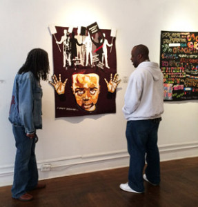 Marion Coleman and Joyce Gordon Gallery curator Eric Murphy in front of Hands Up Don't Shoot by Jackie Houston. To the right can be seen part of Graffiti Art by Frances Porter.